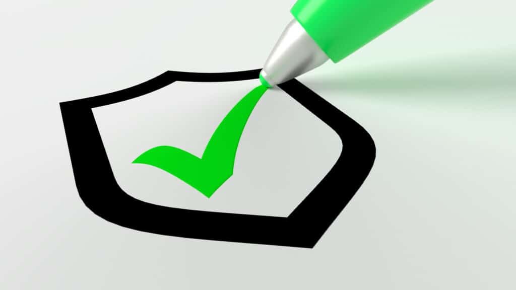 green pen setting a checkmark in a black shield symbol